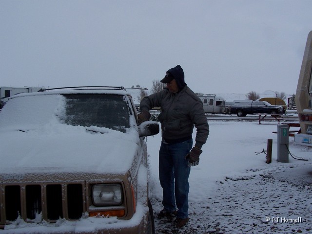 100_1127_MT_Shelby_Snowstorm.jpg - Where did spring go?  Jon trying to clean some of the snow off the windshield so we can rig it for towing. ~May 12, 2004 - Shelby, Montana