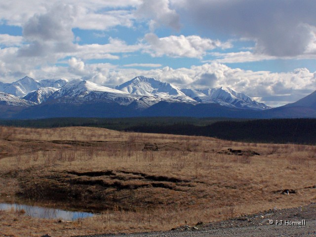 100_8339_YT_AlaskaHighway_Mountains..JPG - Next to the rest area we saw several large sink holes. We wondered if it was safe to park there, but the view was great. Milepost 1149.6 Alaska Highway, Yukon Territory, Canada.  ~May 19, 2006