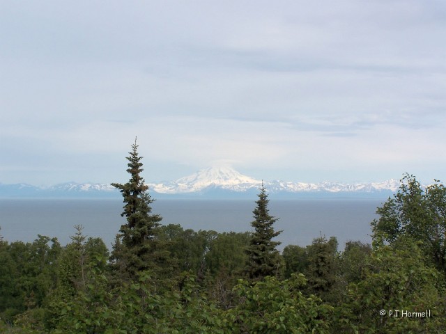 100B9930_AK_Ninilchick_MtRedoubt.JPG - Mt Redoubt, one of four active volcanoes across the Cook Inlet.  They all are in the Ring of Fire that encircles the Pacific Ocean and are part of the Alaska Peninsula-Aleutian Range.  From where we stood the mountain was 54-miles away.  Sterling Highway Milepost 127 near Ninilchick, Alaska  ~June 15, 2006